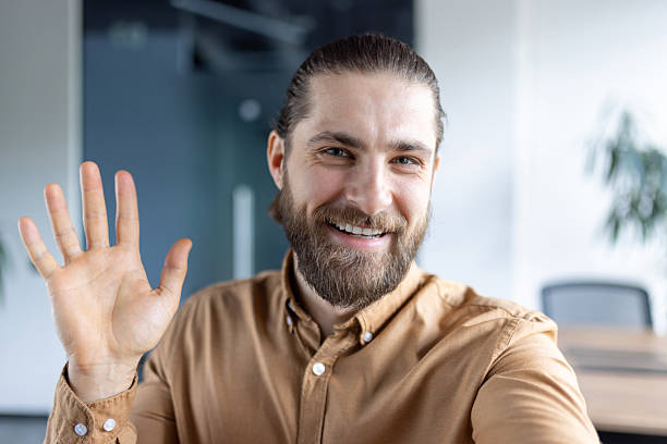 istock Smiling professional man engaging in a virtual meeting from his office 2212633633
