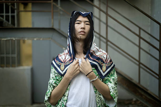 istock Young man wearing silk scarf on head posing in urban setting 2212635616