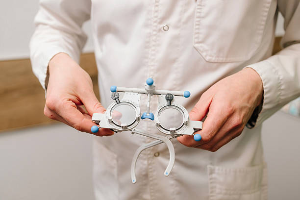 istock Trial frame glasses in ophthalmologist hands. Trial glasses frame eye visual system of people with short or long power vision. 2212637298