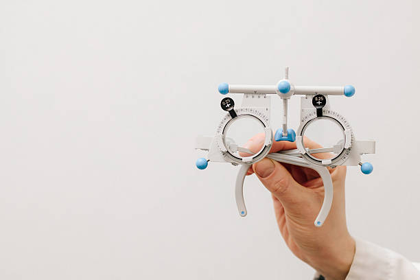 istock Trial frame glasses in ophthalmologist hands on white background. Trial glasses frame eye visual system of people with short or long power vision. 2212637812