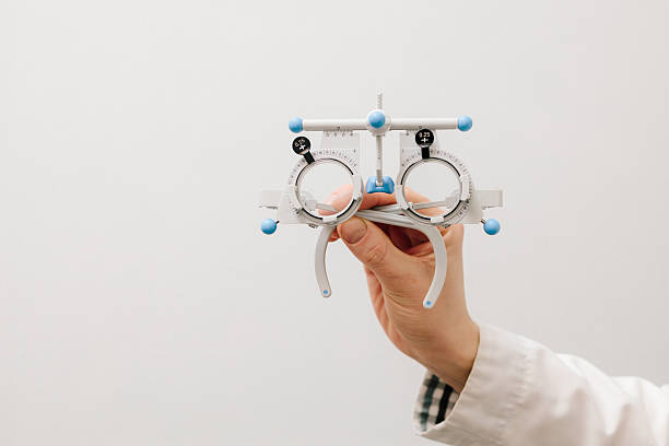 istock Trial glasses frame eye visual system of people with short or long power vision. Trial frame glasses in ophthalmologist hands on white background. 2212637813