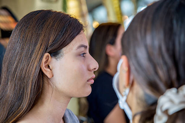 Make-up artist applying foundation on a model's face getting her ready for a photo shoot