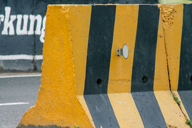 istock Temporary concrete barrier road divider in yellow and black colors. 2212647021