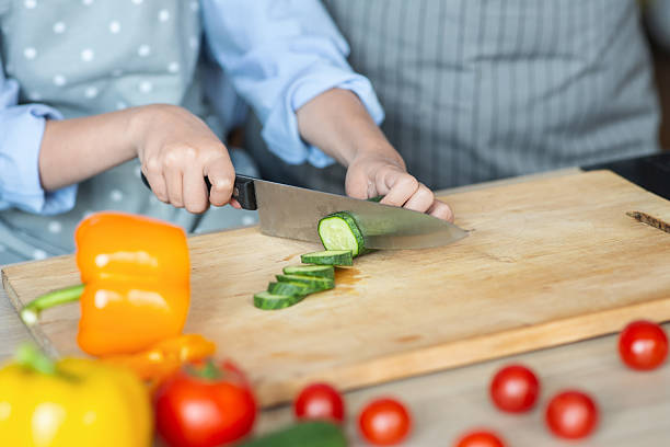 istock Hands of girl learning how to cut vegetables 2212647609