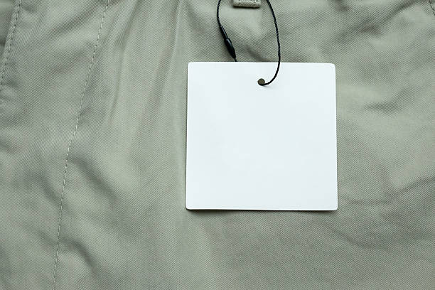 istock Blank white clothes tag label on gray fabric texture background 2212649478