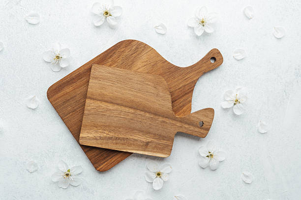 istock Wooden cutting boards arranged on a light surface with delicate flowers 2212649986