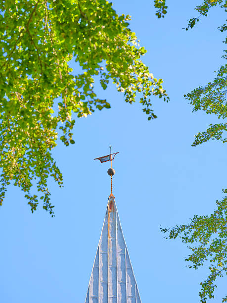 istock Iconic church steeple framed by vibrant foliage with a bright sky 2212650313