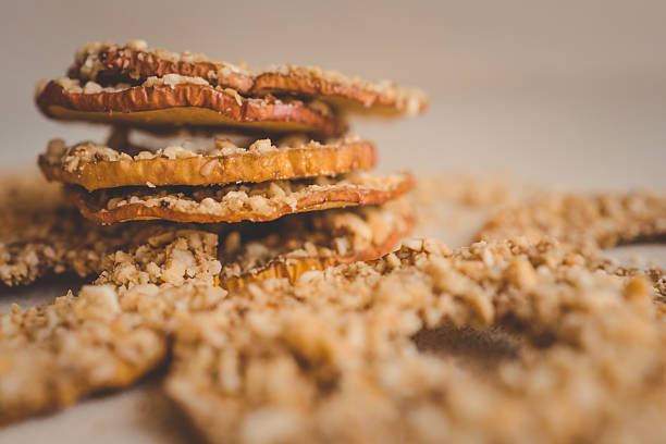 istock Stack of dried apple slices with crushed nuts on top. Healthy homemade fruit chips with nuts on light background. Natural organic snack, vegetarian food, diet dessert, close-up 2212653876