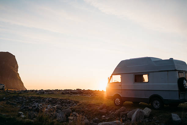 istock Campervan parked by rocky shore at golden sunset 2212661696