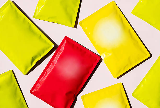 istock Blank Plastic Pouches Arranged Across Flat Surface. Many Foil Packets for Product Packaging Mockup. 2212664394