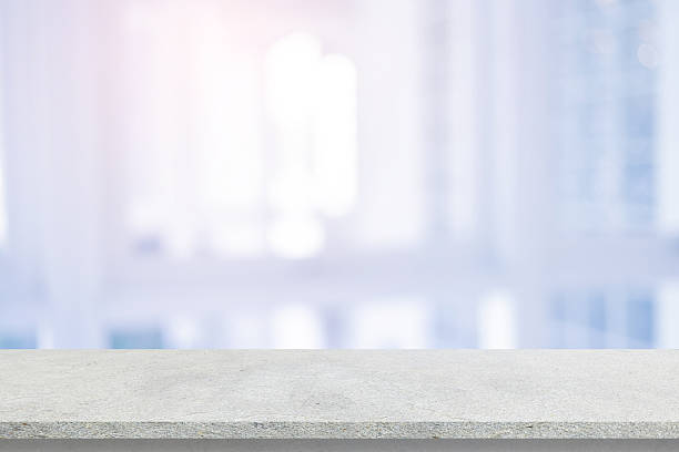 istock Abstract blurred  interior modern office room background with perspective cement quartz table for show, promote and design content or product on display concept 2212667859