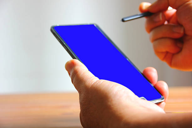 close up man using stylus pen with mobile phone in hand