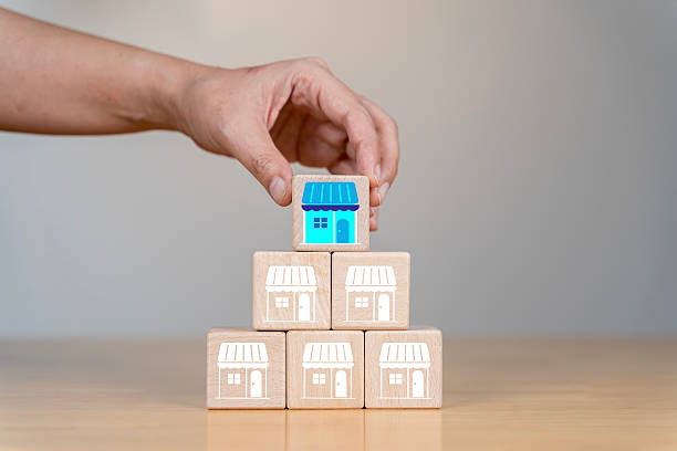 istock Franchise, Close-up hand choose cube wooden toy block stack in pyramid 2212672589