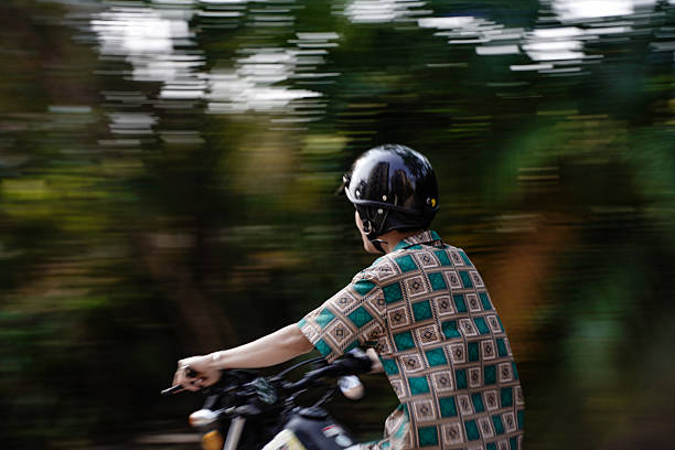 The boy speeding along the road on a motorcycle
