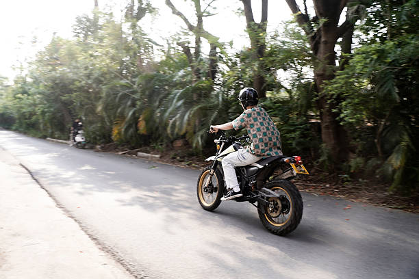 The boy speeding along the road on a motorcycle