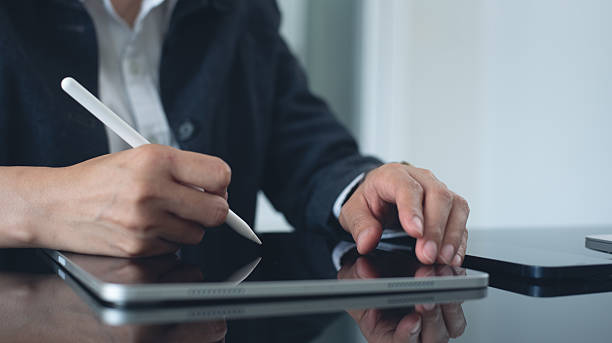 istock Close up, business woman using stylus pen signing e-document on digital tablet via mobile app at office, e-signing, Businesswoman working and surfing the internet, on digital tablet pc 2212674767