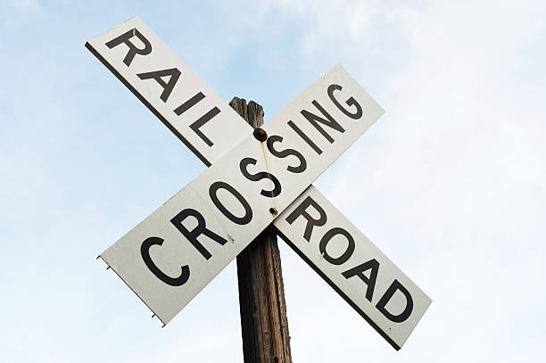 istock railroad crossing sign against sky 2212675486