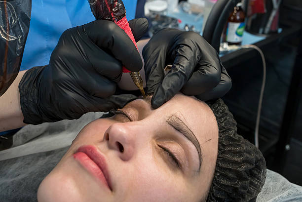 istock The cosmetologist makes a permanent makeup of the eyebrows on a woman's face. 2212677802