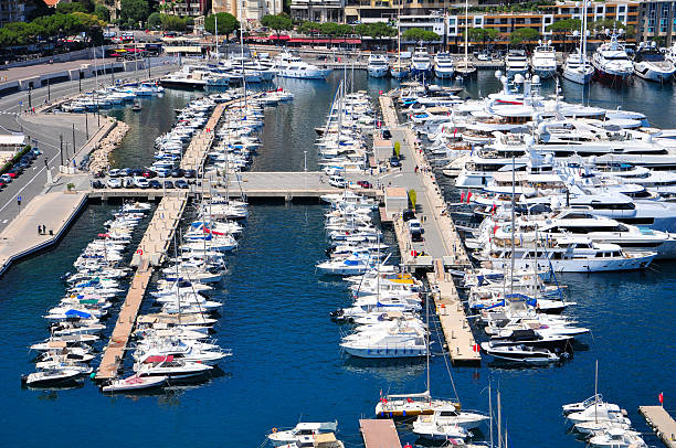 Monte Carlo, Monaco - January 18, 2012: Aerial View of Motor Boats Sailboats and Yachts Moored at Hercules Harbour Floating Pier Sunny Winter Day.