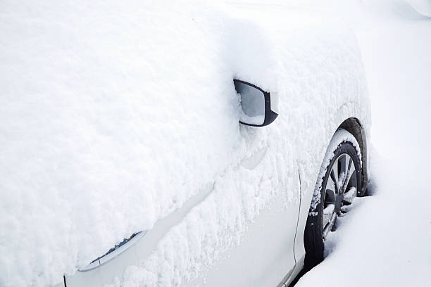 istock snow covered car with only side view mirror out 2212678498