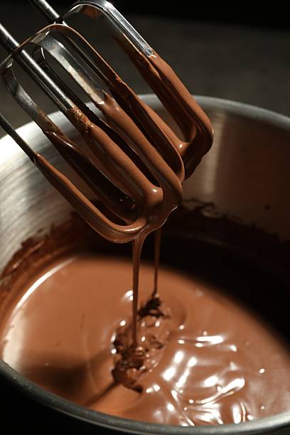 istock Chocolate dough dripping from mixer into bowl, closeup 2212678720