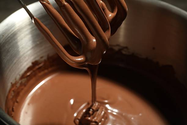 istock Chocolate dough dripping from mixer into bowl, closeup 2212678747