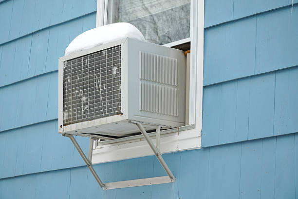 istock old air conditioner installed on house window after winter snow 2212678978