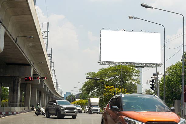 istock Road with lanterns and large blank billboard at evening in city. 2212679108