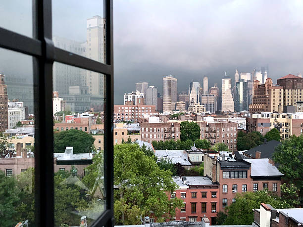 istock View of lower Manhattan with dramatic storm clouds in background from Brooklyn open window. 2212681075
