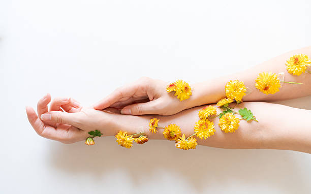 istock The hands decorated with yellow flowers lie on a light background, creating a bright and cheerful composition. 2212681649