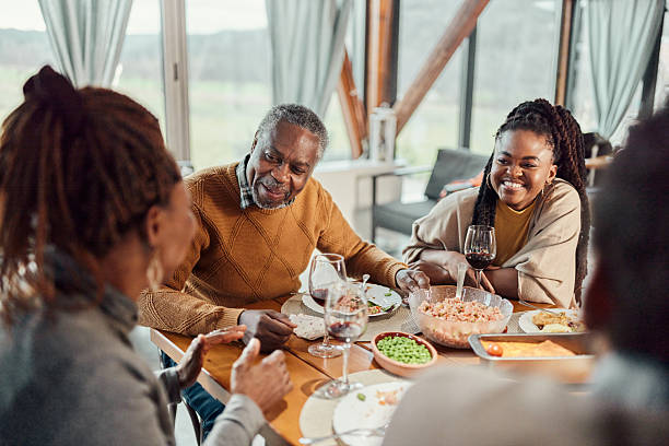istock Happy black family talking during a meal at dining table. 2212682182