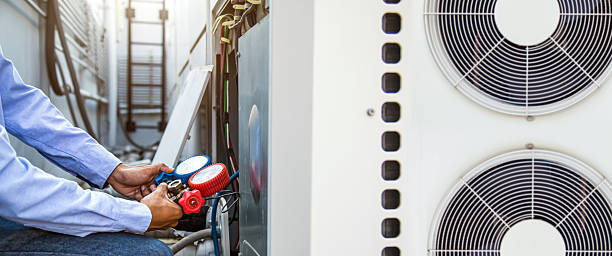 istock Heating and Air Conditioning, HVAC AC system service technician using measuring manifold gauge filling industrial air conditioner after air duct cleaning and checking maintenance outdoor compressor. 2212684162