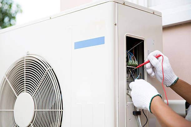 istock Technician Air-conditioning repairman using measuring equipment checking electric at circuit breaker on outdoor air compressor unit after install and check refrigerant system maintenance. 2212684168