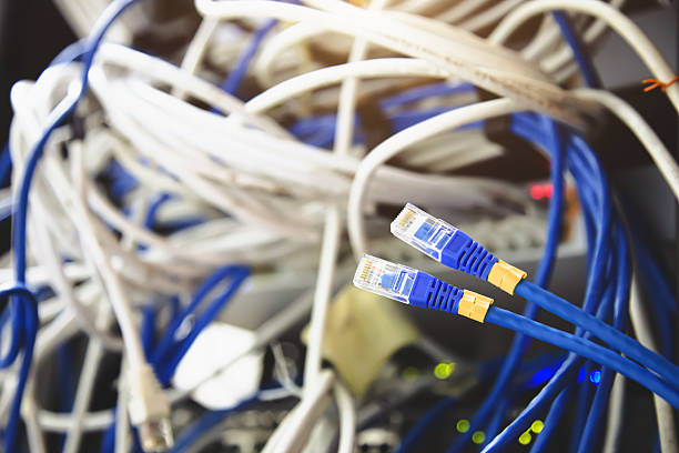 istock Close-up UTP LAN network cable and Lots of Ethernet cables background for connect computer and networking devices such as switch or hub modem router in rack cabinet. 2212685187