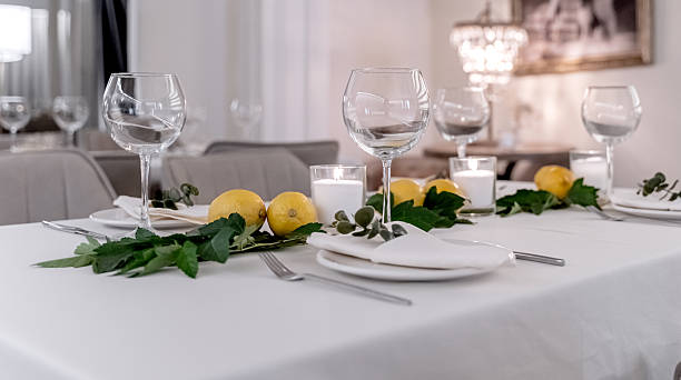 istock beautiful table decoration in restaurant. festive table setting in restaurant. white tablecloth on table, wine glasses, white plates, lemons, candles are burning. romantic atmosphere 2212687075