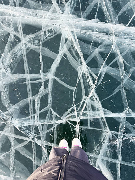 istock Walking on frozen lake baikal ice with cracks captured from above 2212689277