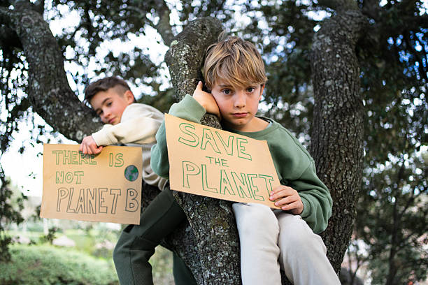 Group of children outdoors cheer and pose with a large blank poster, expressing joy and friendship.
