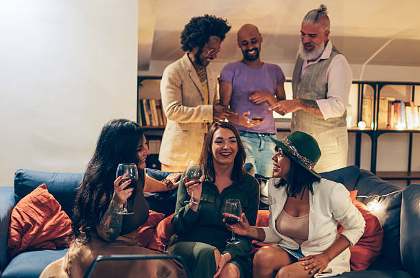 istock Friends drinking wine and talking at a party, having fun together 2212692134