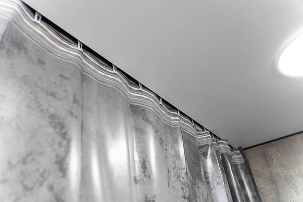 istock Modern gray curtains are hanging from a ceiling track system, adding a touch of elegance and style to the interior design of a contemporary apartment 2212693412