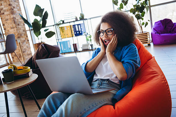 istock Charming businesswoman surprised while working on a laptop in a modern office space, showcasing emotion and productivity 2212695181