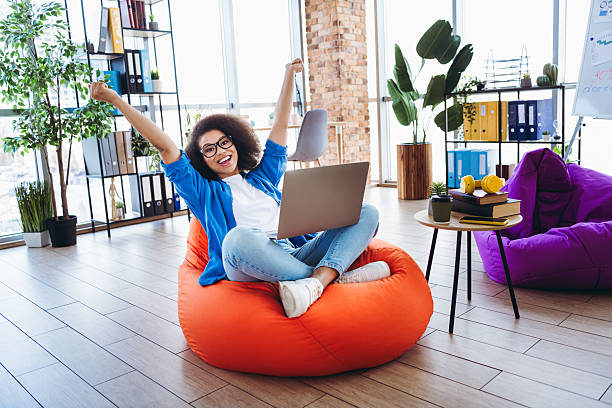 istock Young professional woman celebrating achievement while working in a modern office workspace with a casual feel 2212695236