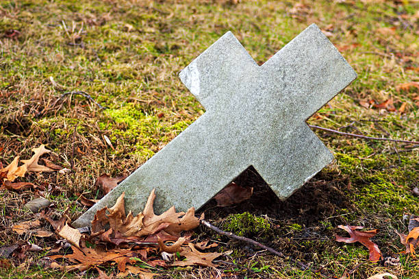istock Fallen Stone Cross on Autumn Leaves 2212696980