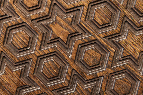 Carved wooden texture featuring decorative geometric patterns of stars and hexagons, showcasing craftsmanship and artistry suitable for design inspiration or background applications