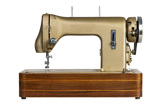 istock Vintage golden sewing machine on wooden base isolated on white 2212698021