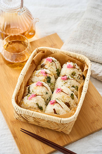 Japanese Spring Rice Balls with Salted Sakura Blossoms in a Bamboo Basket