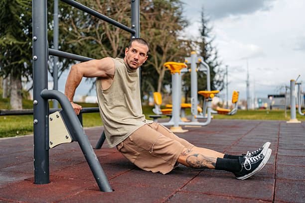 istock Young Man Doing Dips On A Bar In An Outdoor Gym 2212700037