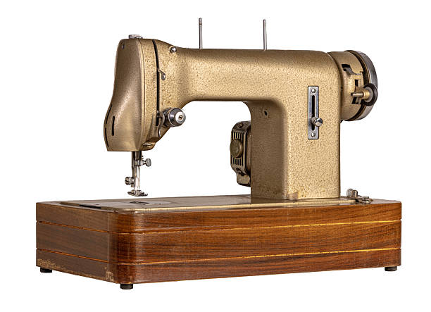 istock Vintage golden sewing machine on wooden base isolated on white background 2212700921