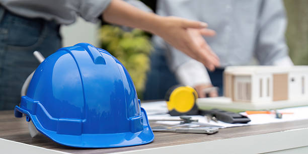 istock Sustainability and Construction Planning. A blue hard hat on a table during a sustainable building project discussion. 2212702426