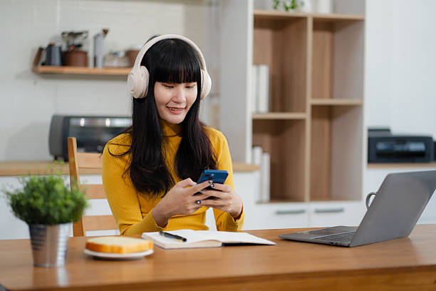 istock Smiling woman in headphones taking notes, motivated interested student studying online, using tablet, watching webinar training or listening to lecture, remote education concept. 2212703338
