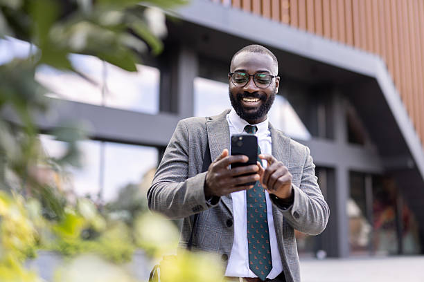 istock Cheerful businessman using smartphone outdoors with focus 2212704312